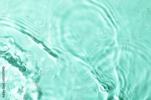 Closeup view of water with rippled surface on light blue background