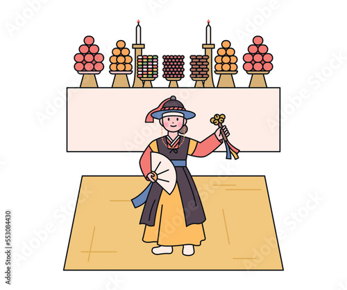 Korean traditional shamanism. A shaman performing a ancestral rite. There is an altar behind her.