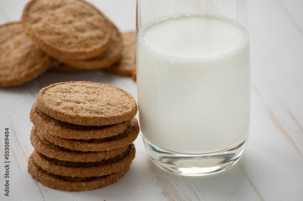 Oatmeal cookies and a glass of milk on a white wooden background. Oatmeal cookies and a glass of milk on a white wooden background.