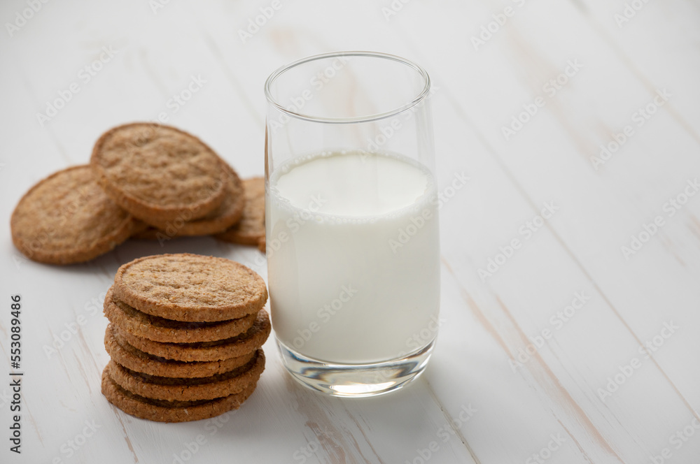 Oatmeal cookies and a glass of milk on a white wooden background. Oatmeal cookies and a glass of milk on a white wooden background.