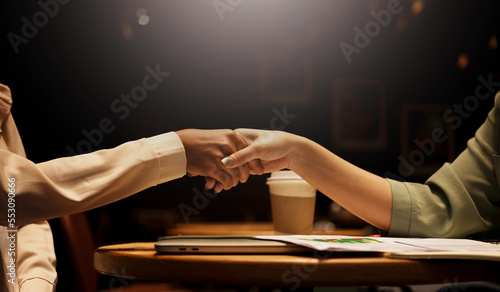 Two Businesswoman shaking hands as sign of successful negotiations.
