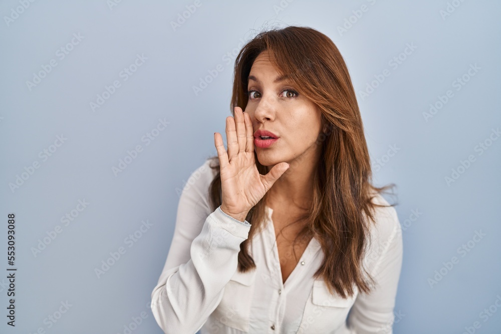 Hispanic woman standing over isolated background hand on mouth telling secret rumor, whispering malicious talk conversation Hispanic woman standing over isolated background hand on mouth telling secret rumor, whispering malicious talk conversation