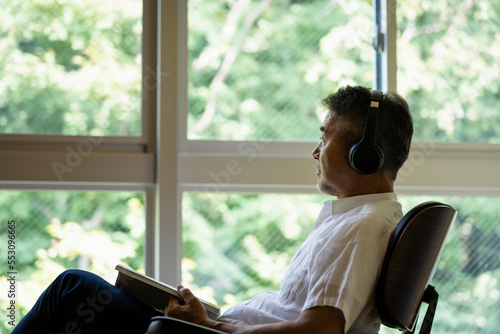 音楽を聴きながら読書をする日本人シニア男性 photo