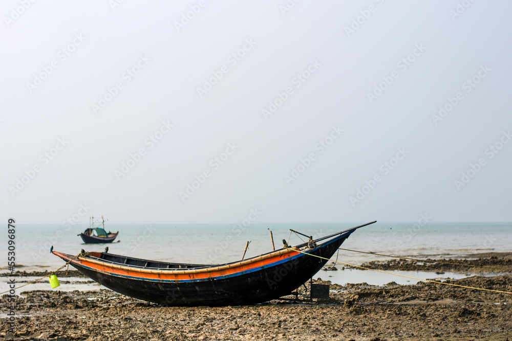 Native wooden fishing boat has been anchored on beach