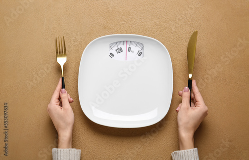 Woman with empty plate and cutlery at table. Diet concept Fototapet