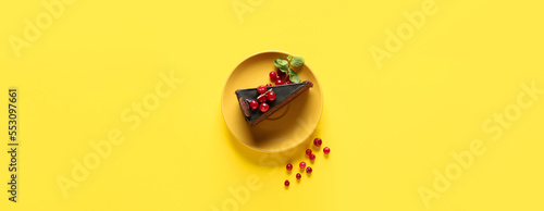 Plate with delicious piece of chocolate cake and berries on yellow background © Pixel-Shot