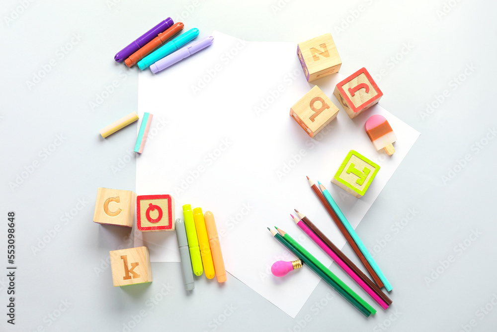 Blank paper sheets with felt-tip pens, pencils and cubes on light background Blank paper sheets with felt-tip pens, pencils and cubes on light background