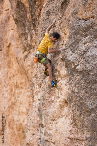 climber climbs the wall. a man is engaged in sport climbing.