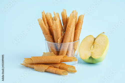 Bowl with delicious apple pastilles on color background