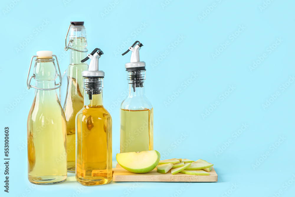 Bottles of apple cider vinegar on color background Bottles of apple cider vinegar on color background