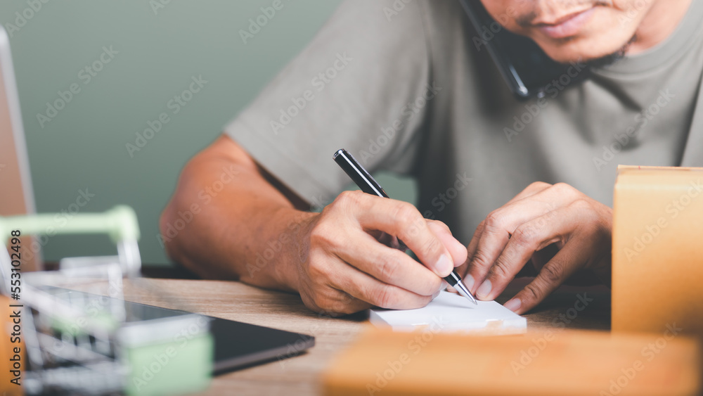 Fototapeta premium Startup or small business entrepreneur,Make a note of the delivery address from the customer,order management in online stores, shopping on the internet,Selling online on the Internet,SME,e-commerce,