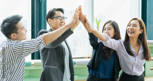 group of young asian woman and man happy greeting together with high five. group of students studying, learning, tutoring in library