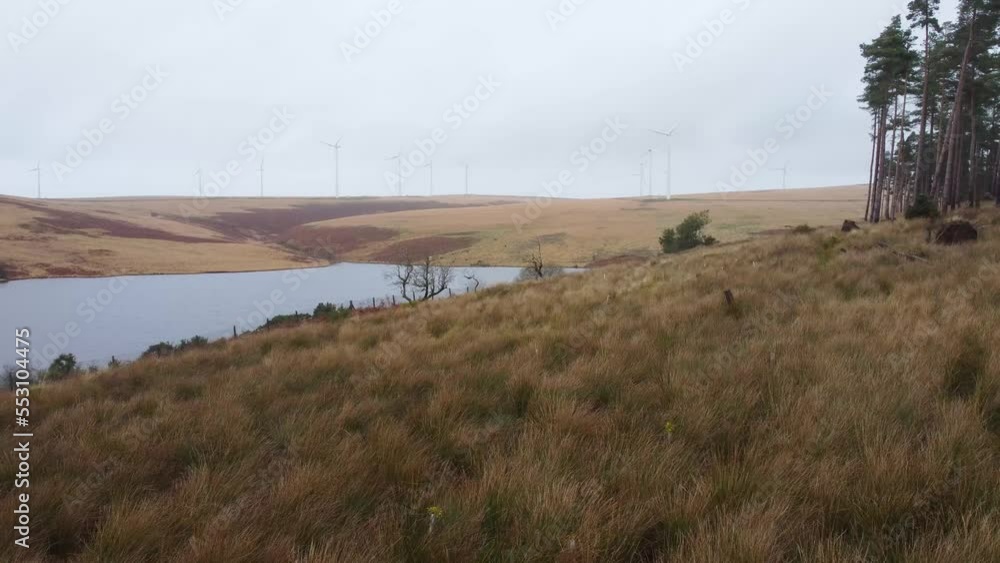 Sideways Aerial of Reservoir with Wind Turbine on Rural Hill Background - Drone shot 4K Sideways Aerial of Reservoir with Wind Turbine on Rural Hill Background - Drone shot 4K