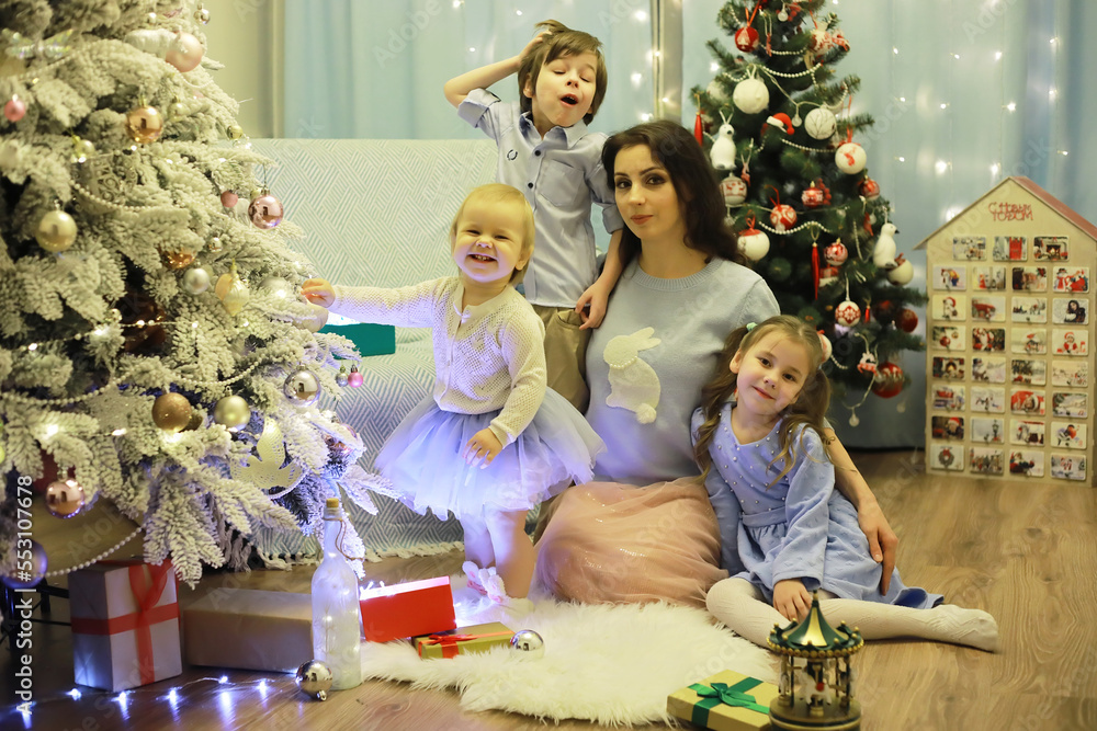 New Years Eve. The house is decorated for the holiday. Christmas tree with a garland and a family with gifts and a surprise. New Years Eve. The house is decorated for the holiday. Christmas tree with a garland and a family with gifts and a surprise.