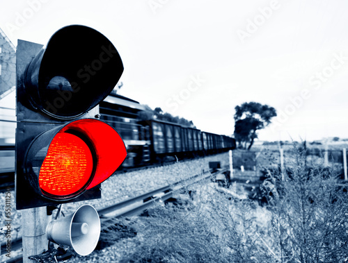 Traffic light shows red signal next to railway lines