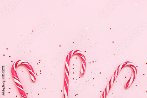 Composition with tasty candy canes and sequins on pink background, closeup © Pixel-Shot