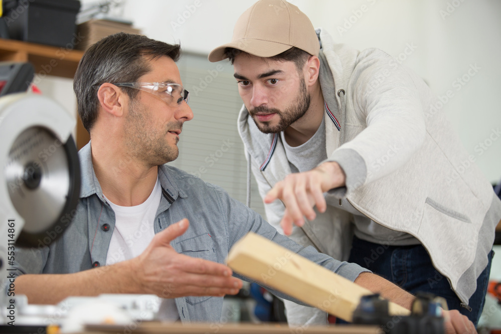 Fototapeta premium carpenter with apprentice in training period