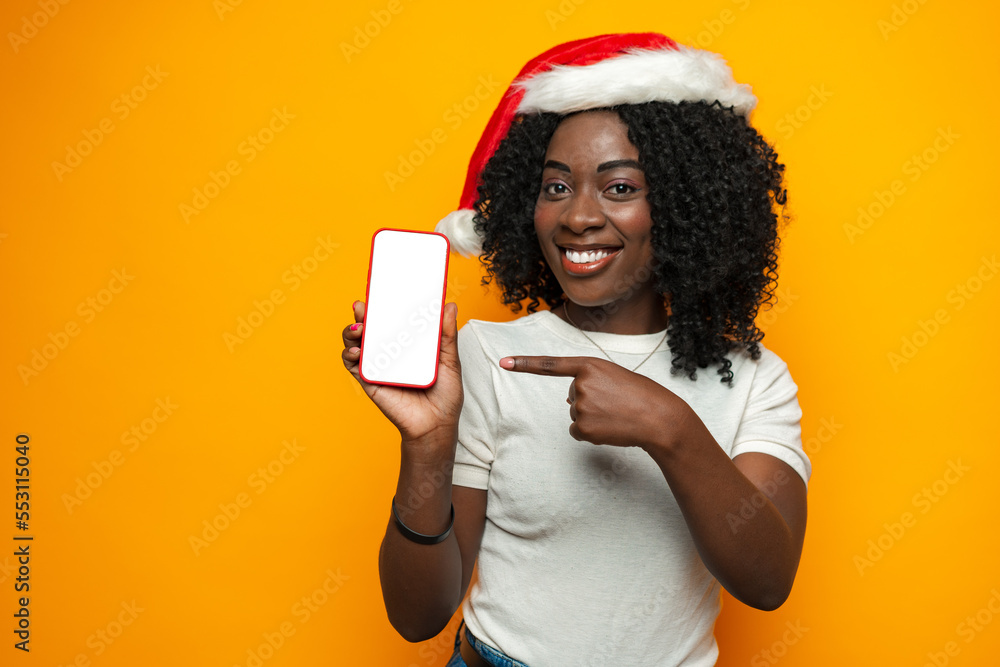 Beautiful african woman wearing santa hat with blank copyspace screen on phone Beautiful african woman wearing santa hat with blank copyspace screen on phone