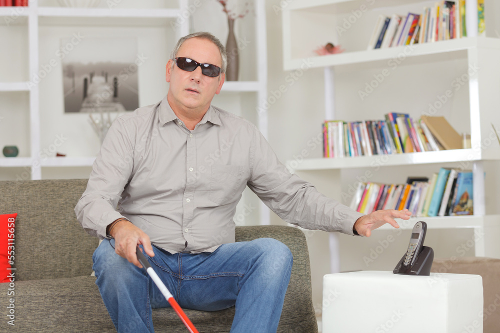 blind man at home reaching for the telephone blind man at home reaching for the telephone