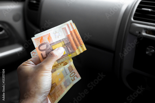 A male businessman pays taxi fare in euros with a tip for excellent service. Business concept.