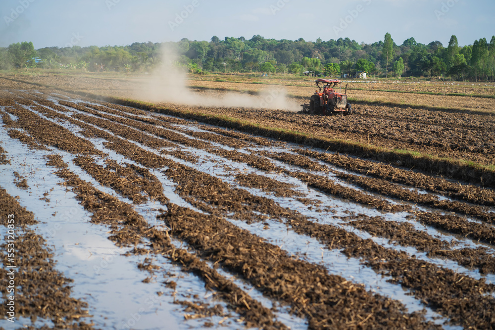 Fototapeta premium Agricultural tractors are plowing the soil in preparation for planting.