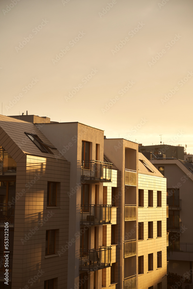 Concept of modern architecture for a better living. Contemporary medium-sized flat building in Europe. Sunset in a European middle house apartment