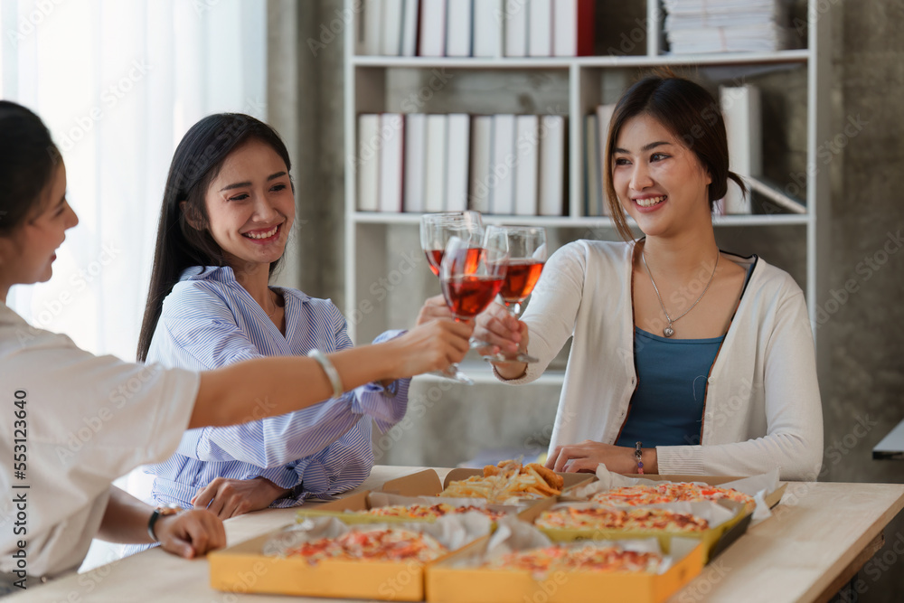 Friends at birthday party clinking glasses with champagne and pizza, enjoying Christmas vacation, pizza on the table. Holiday Party event Friends at birthday party clinking glasses with champagne and pizza, enjoying Christmas vacation, pizza on the table. Holiday Party event