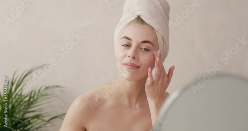 Woman dropping serum on face. European girl applying serum collagen moisturizer