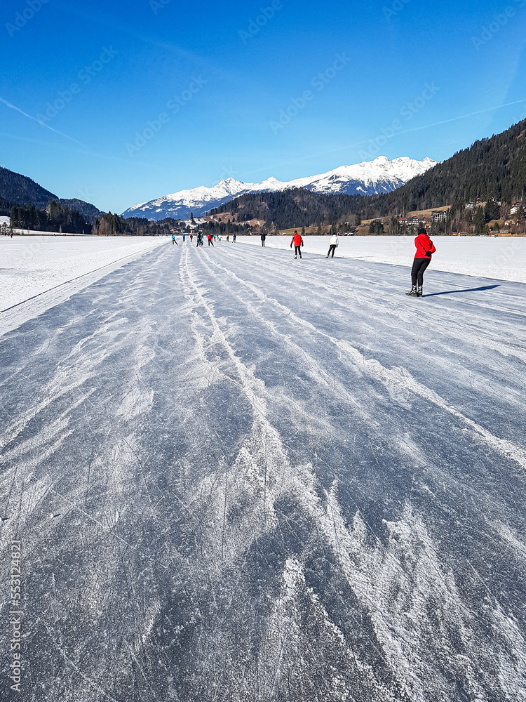 Ice skaters on the Weissensee in Austria in winter