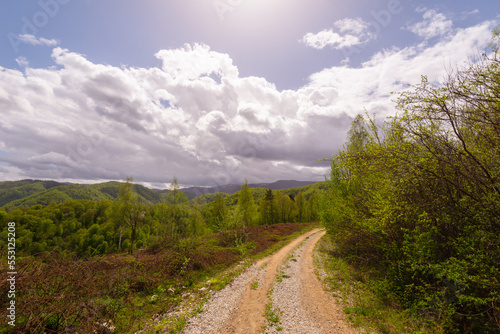 Beautiful country road in spring in remote rural area in Eastern Europe and storm April sky