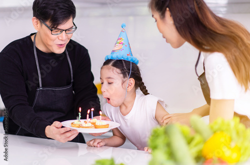 Happy asian family celebrate birthday to young daughter at home together