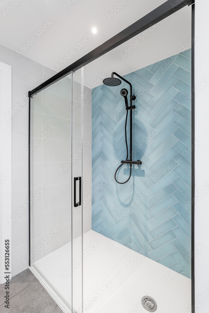 custom made wallpaper toronto digitalWhite bathroom with glass shower, walls are decorated with herringbone tiles in pale blue. Black shower system enclosure with dark matte framed sliding glass door. Bright modern and stylish bathroom