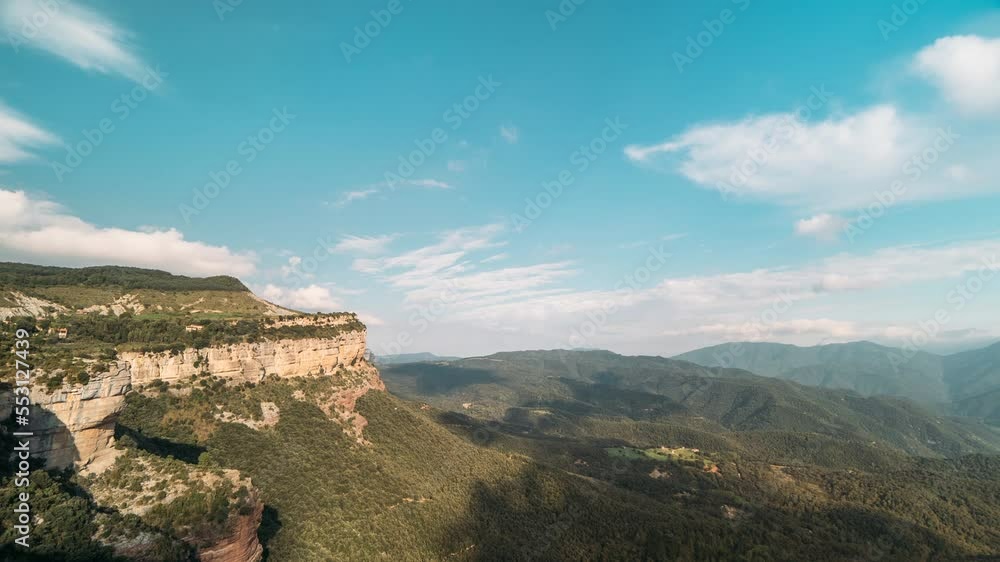 Time-lapse shooting of movement of clouds across blue daytime sky in a mountain green valley. Shadow from clouds floating across the sky on rocks and hills in a mountain valley. Aerial view of nature Time-lapse shooting of movement of clouds across blue daytime sky in a mountain green valley. Shadow from clouds floating across the sky on rocks and hills in a mountain valley. Aerial view of nature