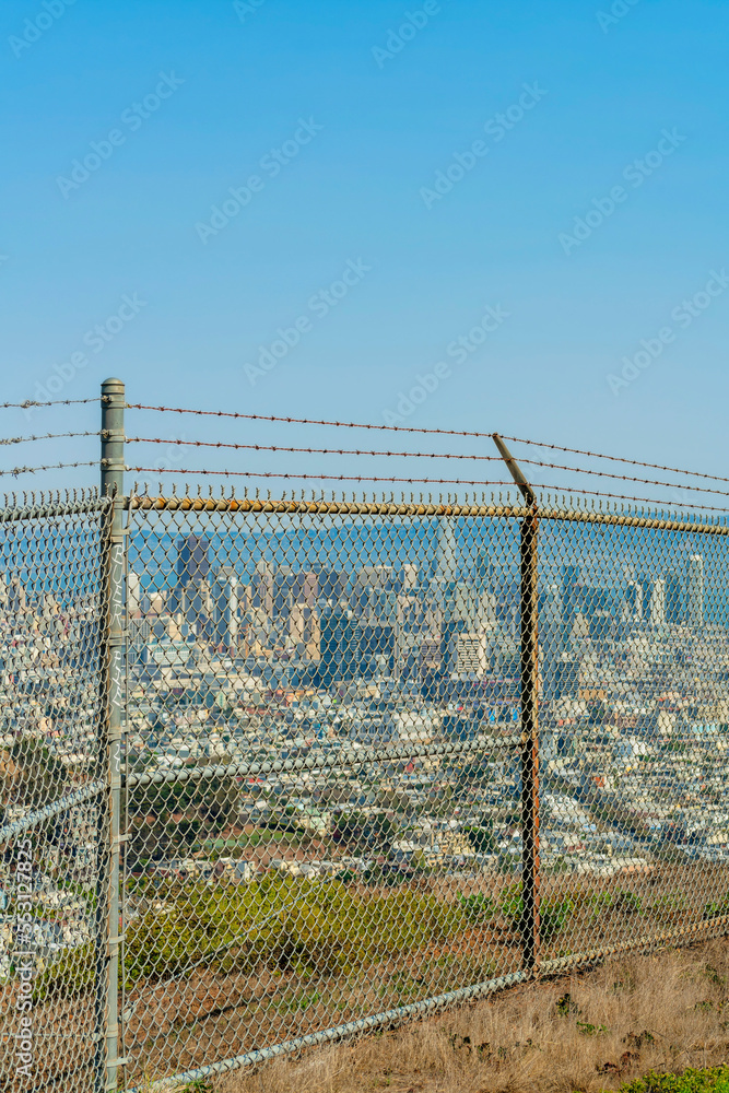 rusty chainlink fence with downtown and ocean background