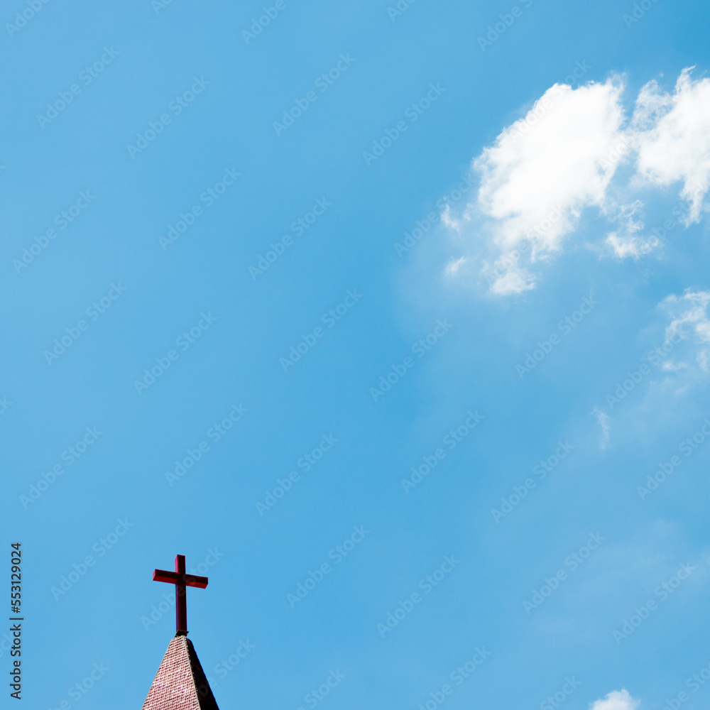 Christian cross on the rooftop against blue sky Christian cross on the rooftop against blue sky