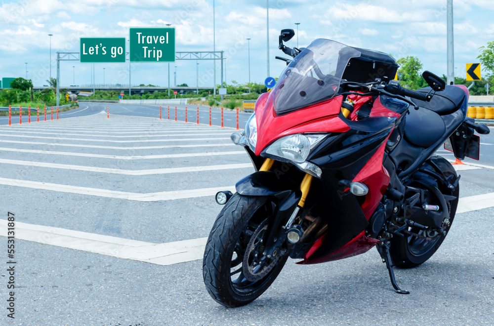 Red black motorcycle modern style parked on road with message Let's go Travel Trip on green roadsign background