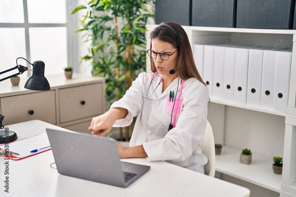 Beautiful doctor woman working on online appointment pointing with finger to the camera and to you, confident gesture looking serious Beautiful doctor woman working on online appointment pointing with finger to the camera and to you, confident gesture looking serious