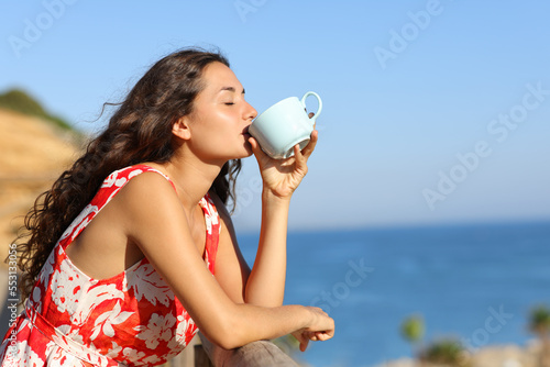 Tourist on the beach drinking coffee photo