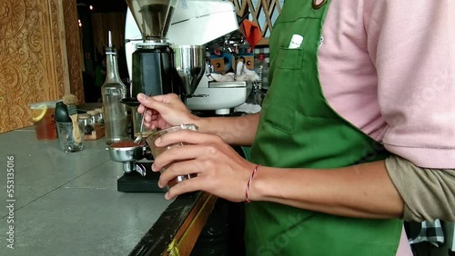 The cafe barista is making an espresso