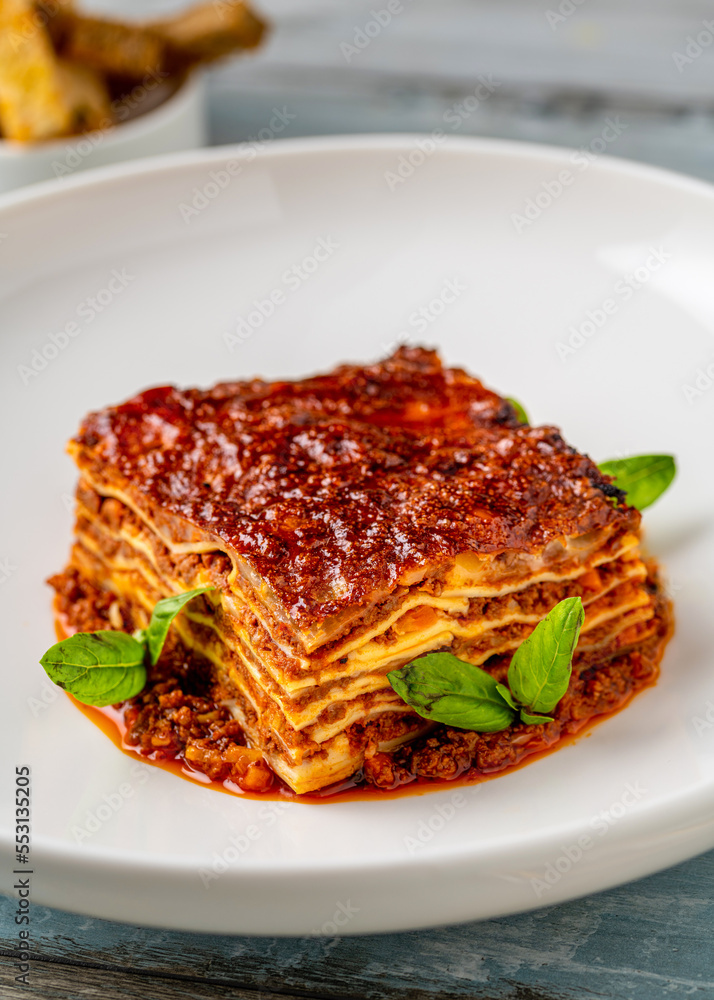 Bechamel sauce and minced meat lasagna on wooden table Bechamel sauce and minced meat lasagna on wooden table