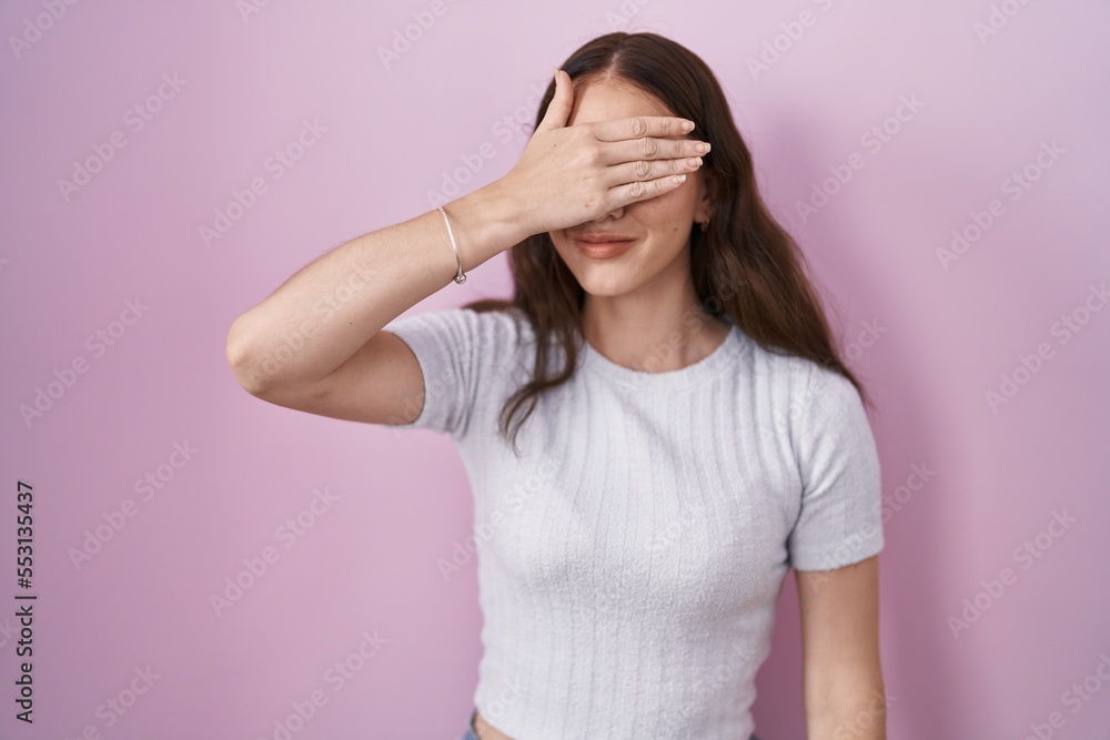 Young hispanic girl standing over pink background smiling and laughing with hand on face covering eyes for surprise. blind concept. Young hispanic girl standing over pink background smiling and laughing with hand on face covering eyes for surprise. blind concept.