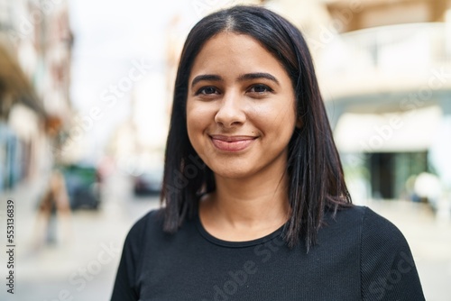 Young latin woman smiling confident standing at street