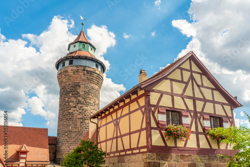 Germany, Bavaria,Nuremberg, Half-timbered house in front of historic Sinwell Tower photo