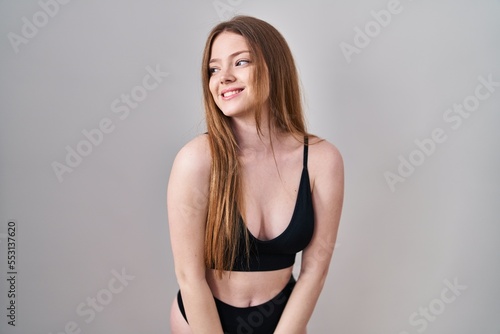 Young caucasian woman wearing lingerie looking away to side with smile on face, natural expression. laughing confident. © Krakenimages.com