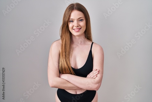 Young caucasian woman wearing lingerie happy face smiling with crossed arms looking at the camera. positive person.