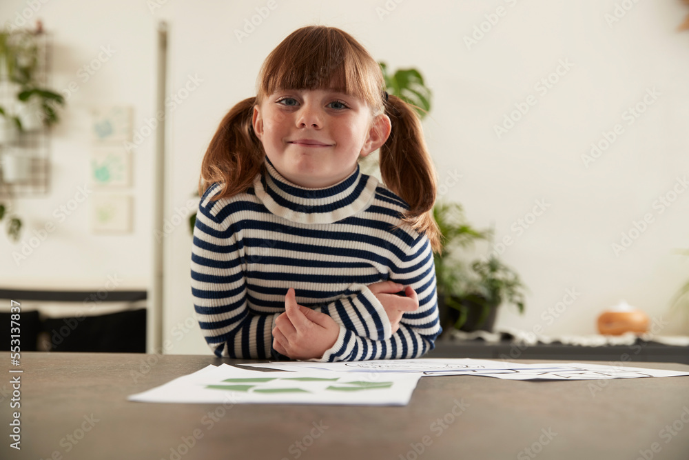 Smiling girl with papers leaning on table at home Smiling girl with papers leaning on table at home