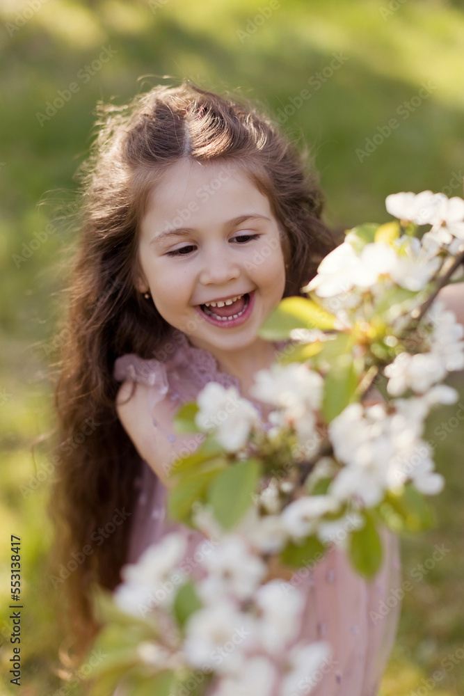 Happy cute girl plucking cherry blossom flowers in garden Happy cute girl plucking cherry blossom flowers in garden