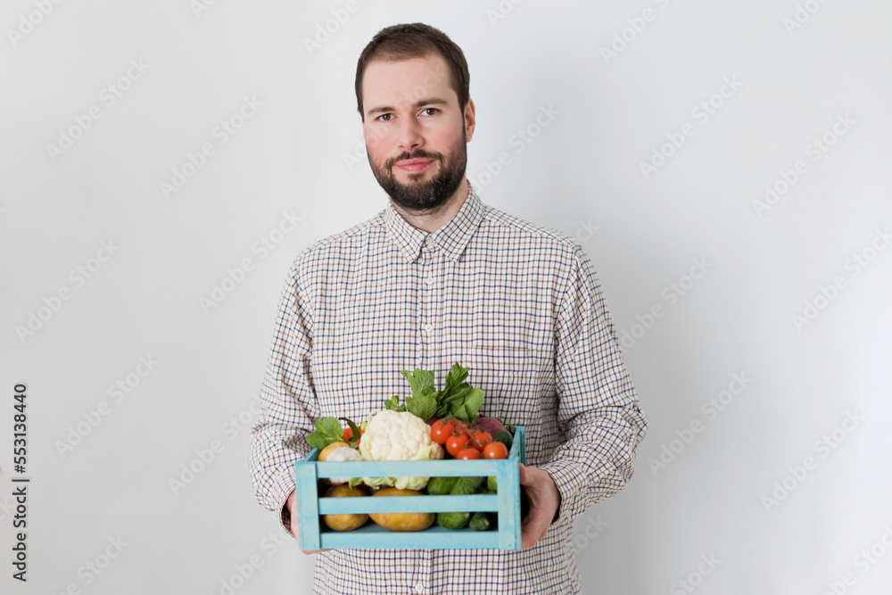 Man holding crate of organic vegetables against white background Man holding crate of organic vegetables against white background
