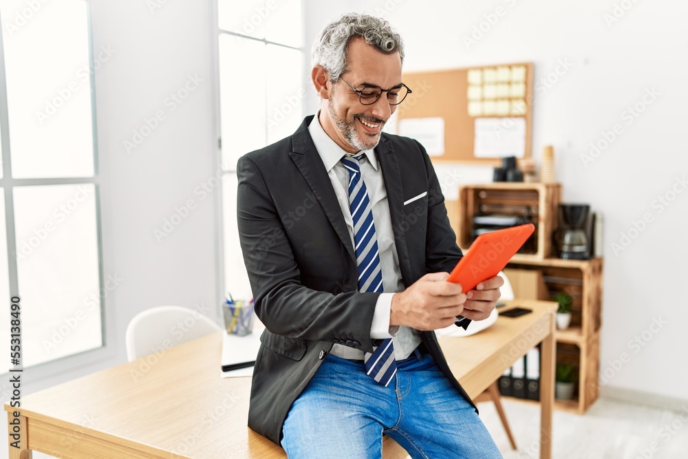 Middle age grey-haired man business worker smiling confident using touchpad at office Middle age grey-haired man business worker smiling confident using touchpad at office