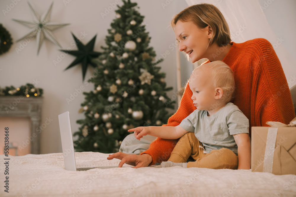 Mother with son using laptop on bed in bedroom Mother with son using laptop on bed in bedroom